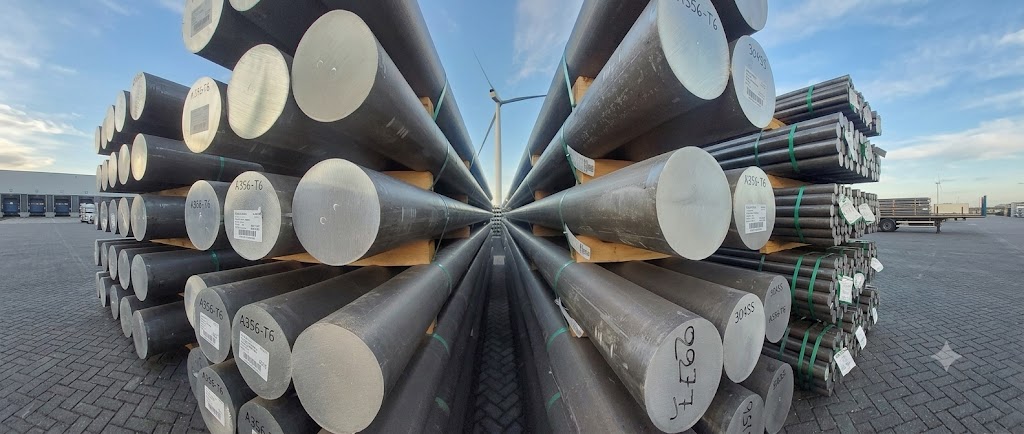 Labelled metal bars stacked by lot for stock inspection at a storage yard