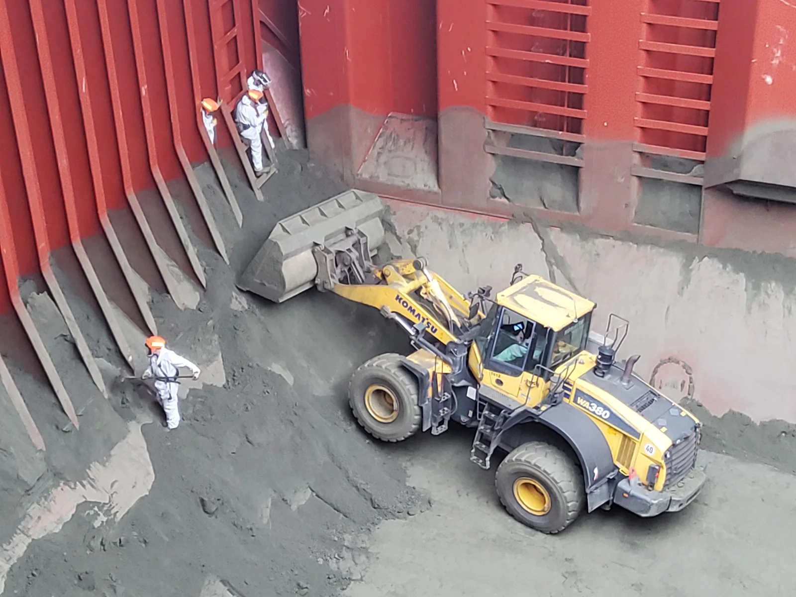 Surveyors sampling bulk material inside a vessel hold